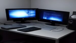 A sleek black laptop with illuminated keyboard and holographic game graphics floating above it