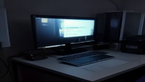 Two premium handheld gaming PCs placed side by side on a dark matte surface with soft glowing edges, modern minimalist gaming aesthetic